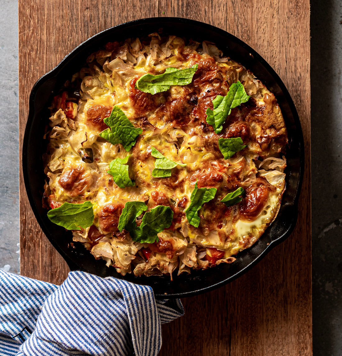 delicious food in cast iron pan on cutting board